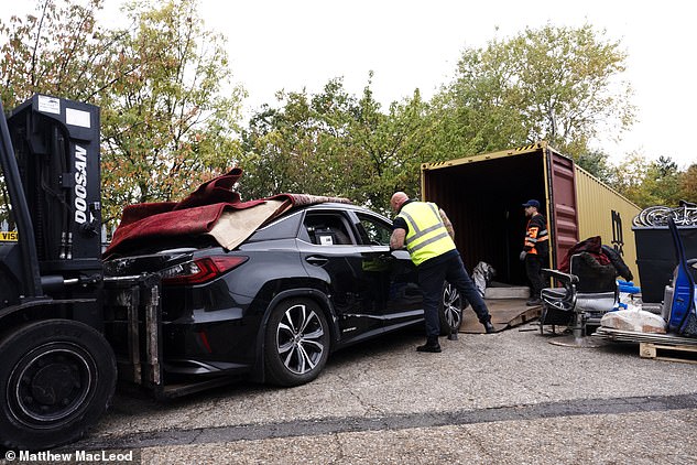 A cargo crew removes one of the stolen Lexus cars that was due to be shipped to the Middle East