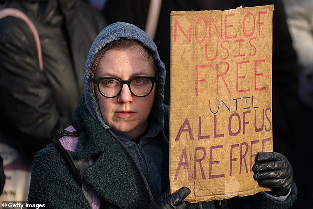 EDNIGBURGH: A trans rights activist holds up a placard which reads 'None of us is free untill all of us are free'