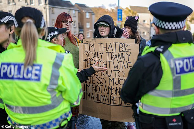 Trans Rights activist hold placards and display banners while taking part in a counter protest in Edinburgh