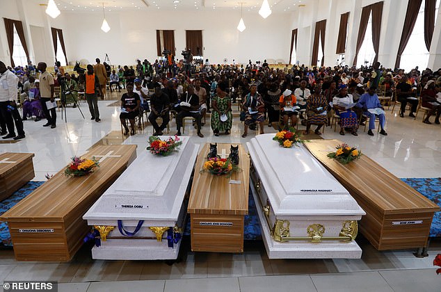 Coffins are seen arranged inside a hall during a mass memorial service for victims of an attack