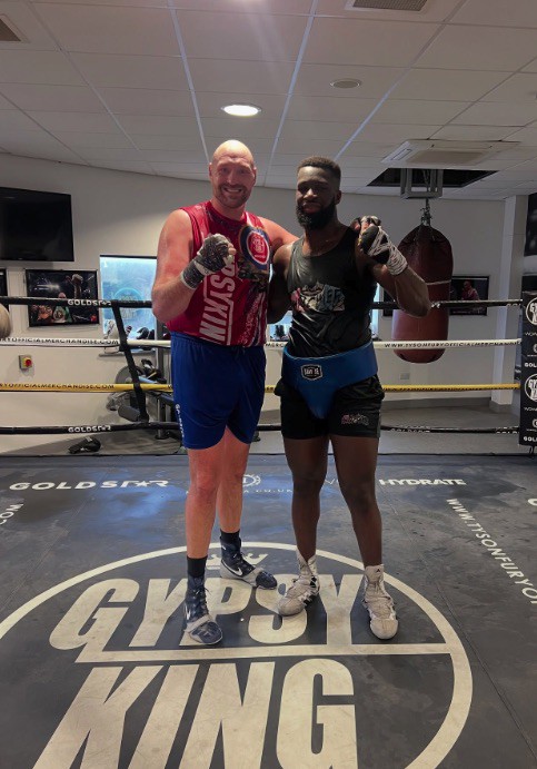 Tyson Fury and Isaac Lowe posing in a boxing ring.