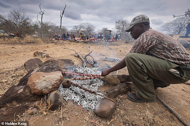 Village chef Livingstone cooks kebabs from elephant meat near the culling site