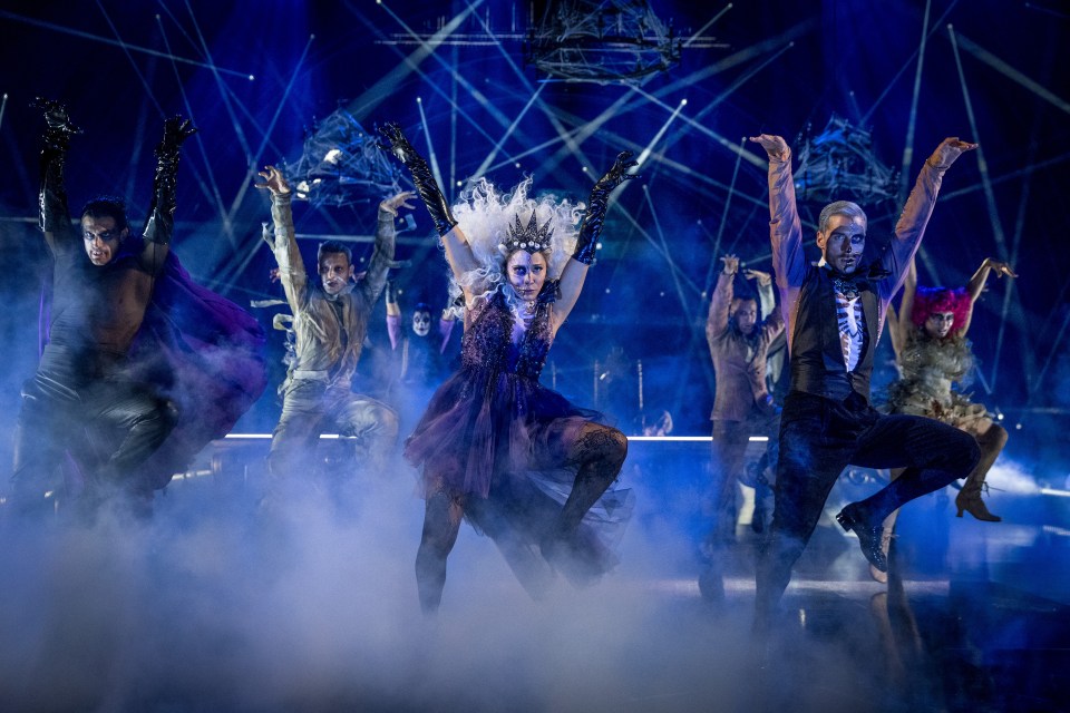 Strictly Come Dancing performers in Halloween costumes dancing on a misty, blue-lit stage.