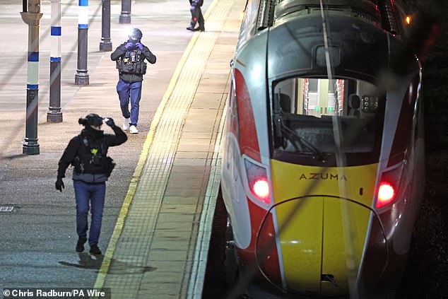 Police on the platform by the train at Huntingdon station in Cambridgeshire after the mass stabbing