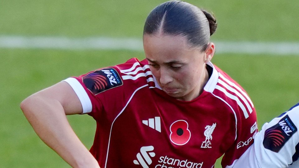 Mia Enderby wearing a red Liverpool FC jersey with a poppy on it.