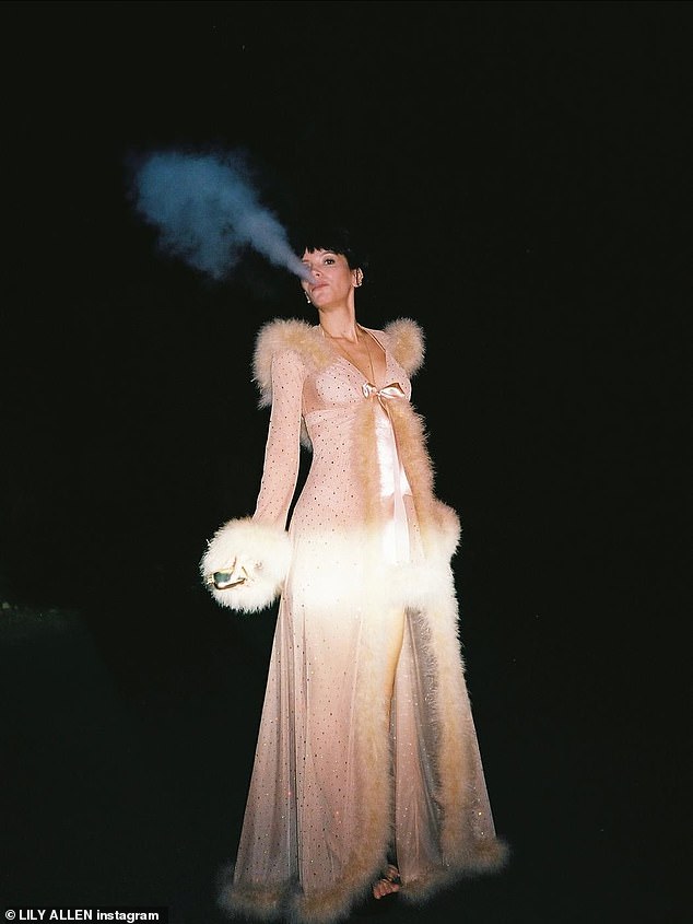 She flashed her gorgeous smile while posing for photos outside and puffing on an e-cigarette