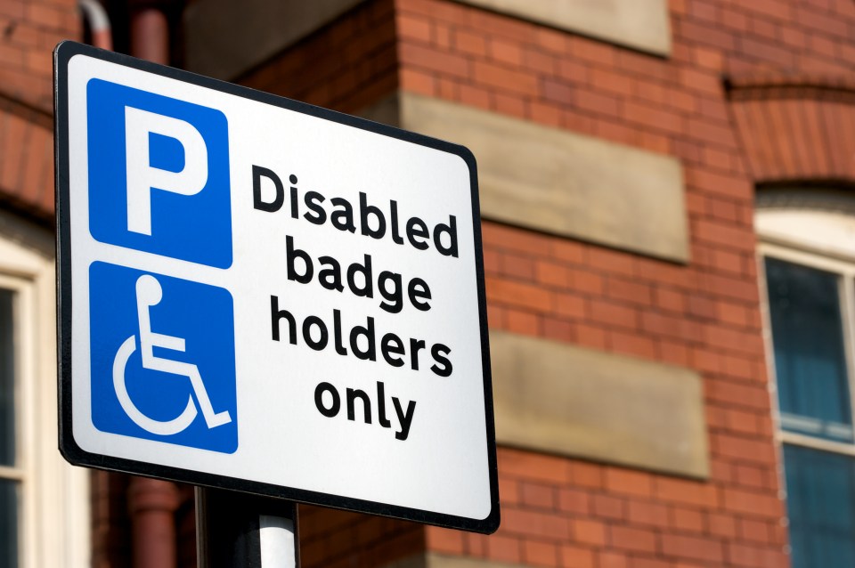 Parking sign with a blue P and a wheelchair symbol, and the text "Disabled badge holders only."