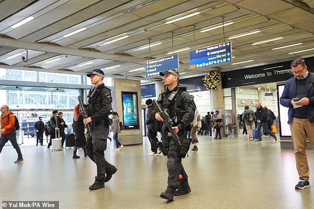 Security has been stepped up at train stations following the attack (pictured: armed police at St Pancras International Station in London on Monday morning)