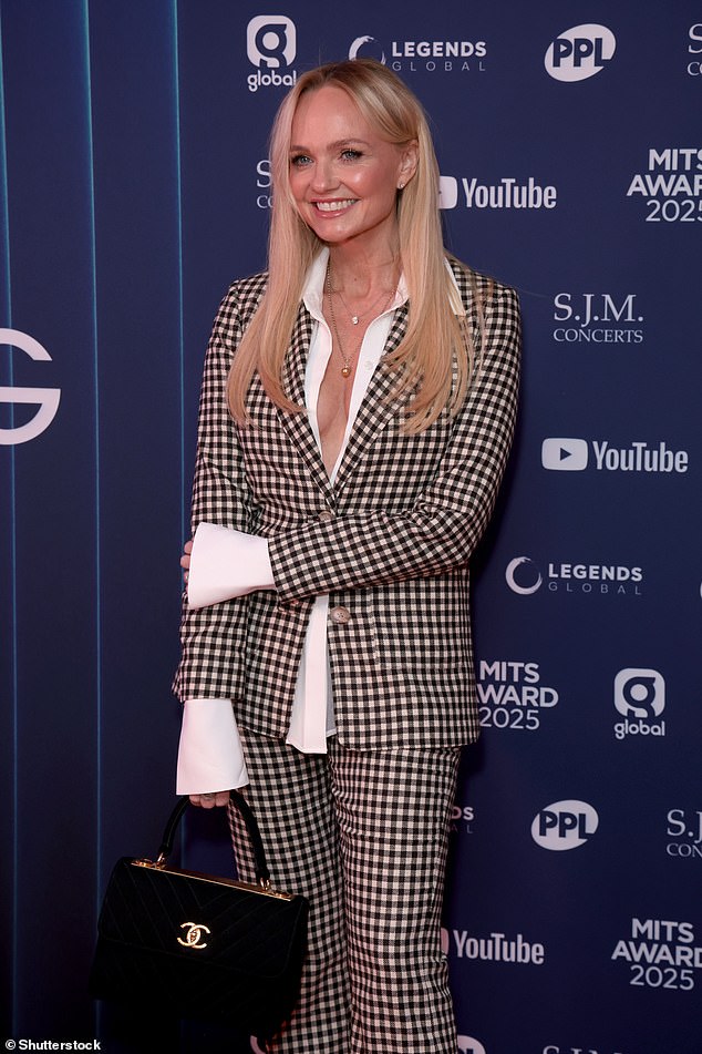 The Spice Girl looked chic in the blazer and matching wide legged trousers which she teamed with an unbuttoned white shirt beneath