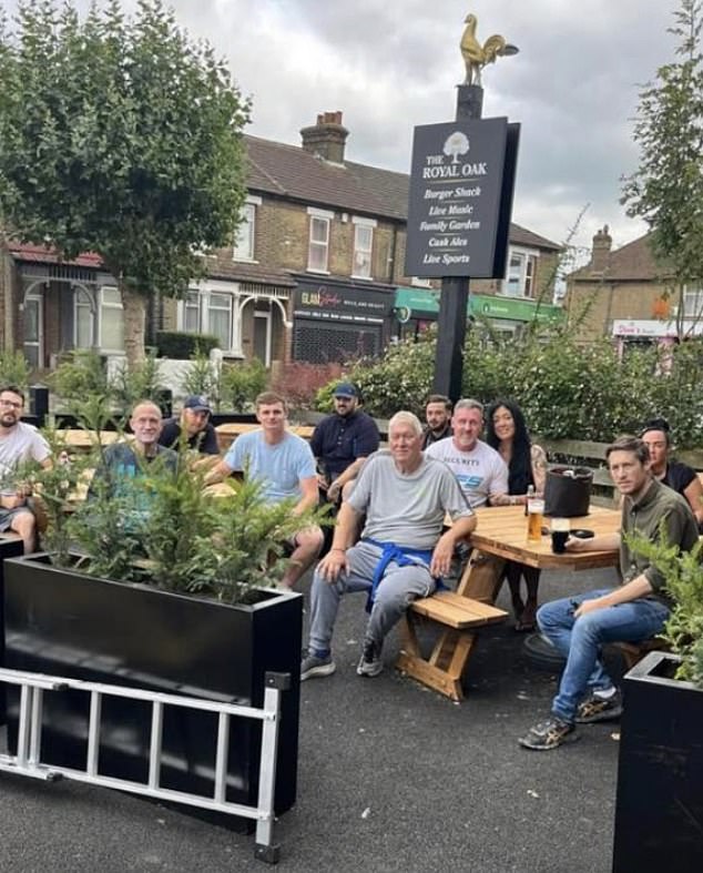 The 'Bexley flagsters' are pictured having a 'well-earned break' at the Royal Oak pub in Erith, London