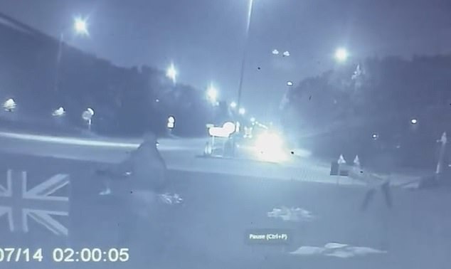 Bits of flag are seen lying on the grass as the area is wiped clear of the ornaments