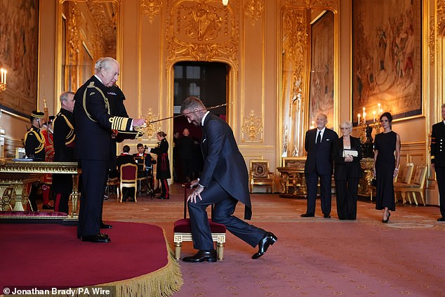 Sir David bowed before the King while being recognised for his services across sport and charity on Tuesday morning