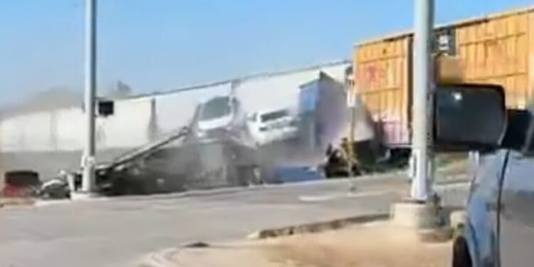 Watch shocking moment freight train crashes with giant 18-wheeler lorry loaded with cars in crunching T-bone smash