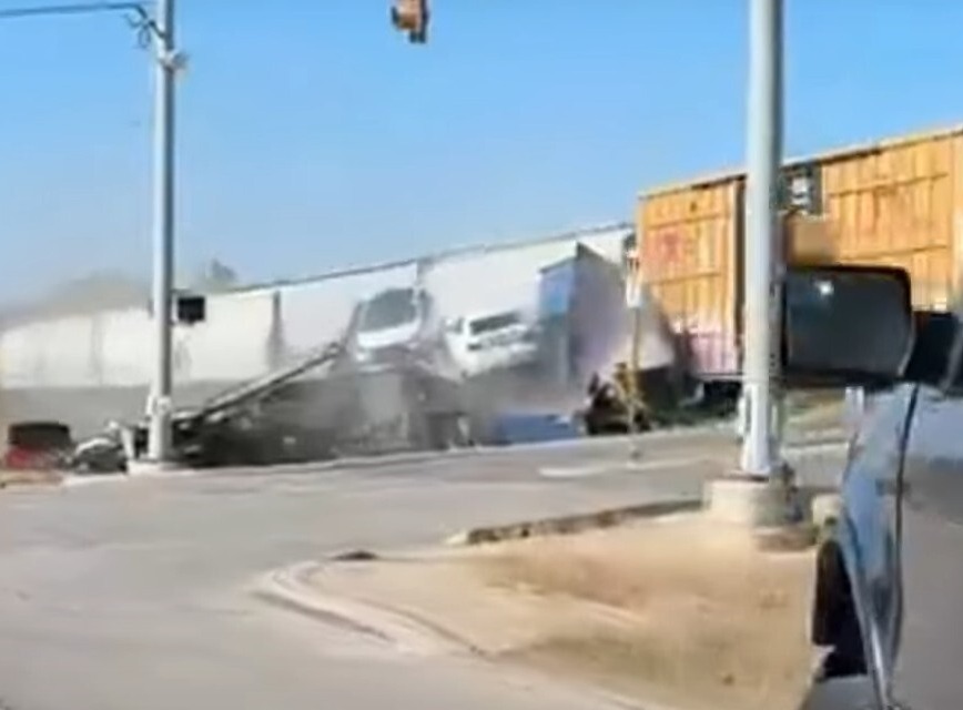 Watch shocking moment freight train crashes with giant 18-wheeler lorry loaded with cars in crunching T-bone smash