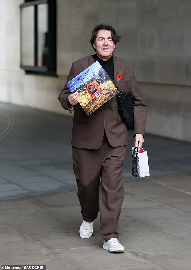 Jonathan Ross was also snapped as he arrived, looking windswept in a brown suit with a black T-shirt underneath
