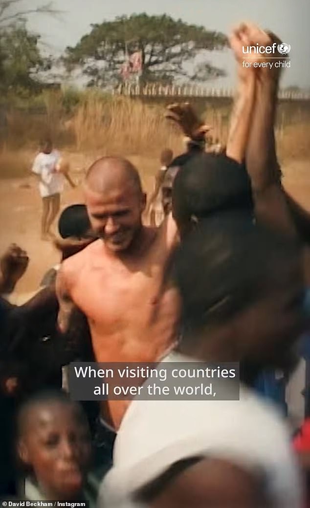 In another throwback, a shirtless Sir David was mobbed by children playing football on a sandy pitch as the ambassador smiled