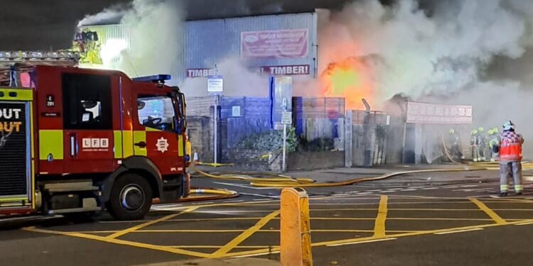 Dozens of firefighters battle huge industrial blaze as major tunnels shut and football fans told 'stay away'