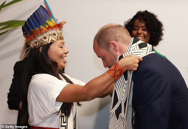 She places the black and cream scarf over his head and tells William it took three hours to make