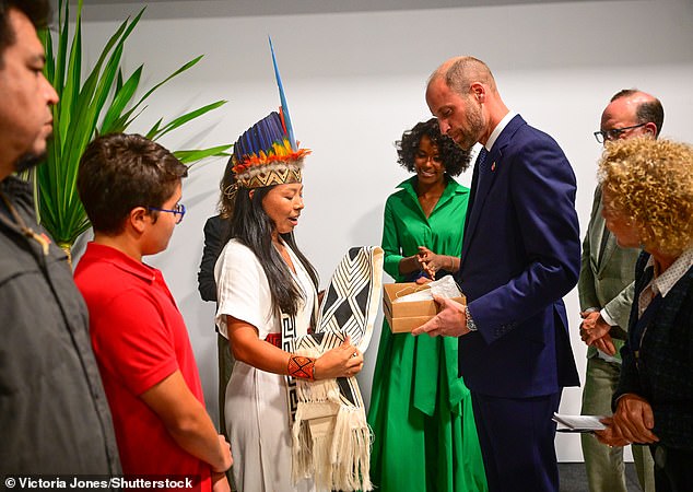 Vanda Witoto (left) Climate Activist, Indigenous Leader and Executive Director of Witoto Institute, drapes a garment on William during the summit