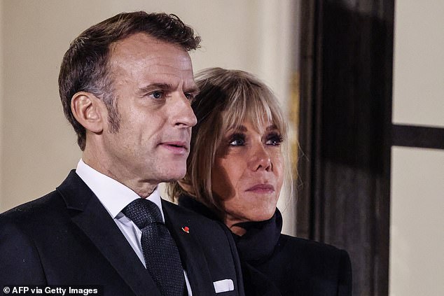 France's President Emmanuel Macron (L) and his wife Brigitte wait to welcome guests for a dinner hosting participants of the 8th Paris Peace Forum, at the Elysee Palace in Paris, on October 29, 2025