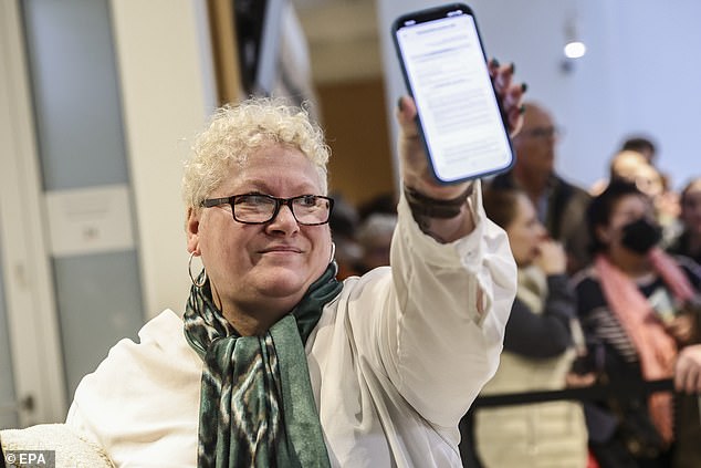 Defendant Amandine Roy shows her convocation on her phone on the first day of the trial for sexist cyberbullying against Brigitte Macron, wife of French President Emmanuel Macron, at the Paris Court in Paris, France, 27 October 2025