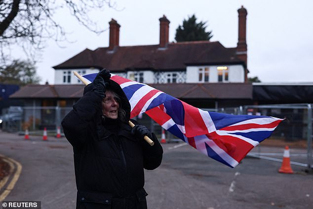 A woman with a Union Jack flag protests near The Bell Hotel, following the mistaken release of  Kebatu