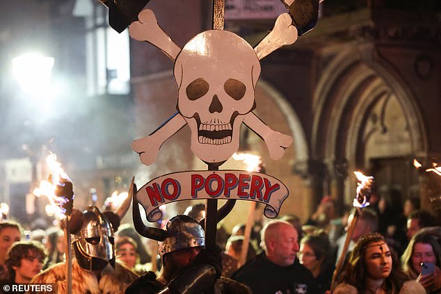 One bonfire attendee in Lewes held a cutout skull with a sign below reading 'No popery' - in reference to both the Gunpowder Plot and a group of Protestant martyrs burned at the stake in the town