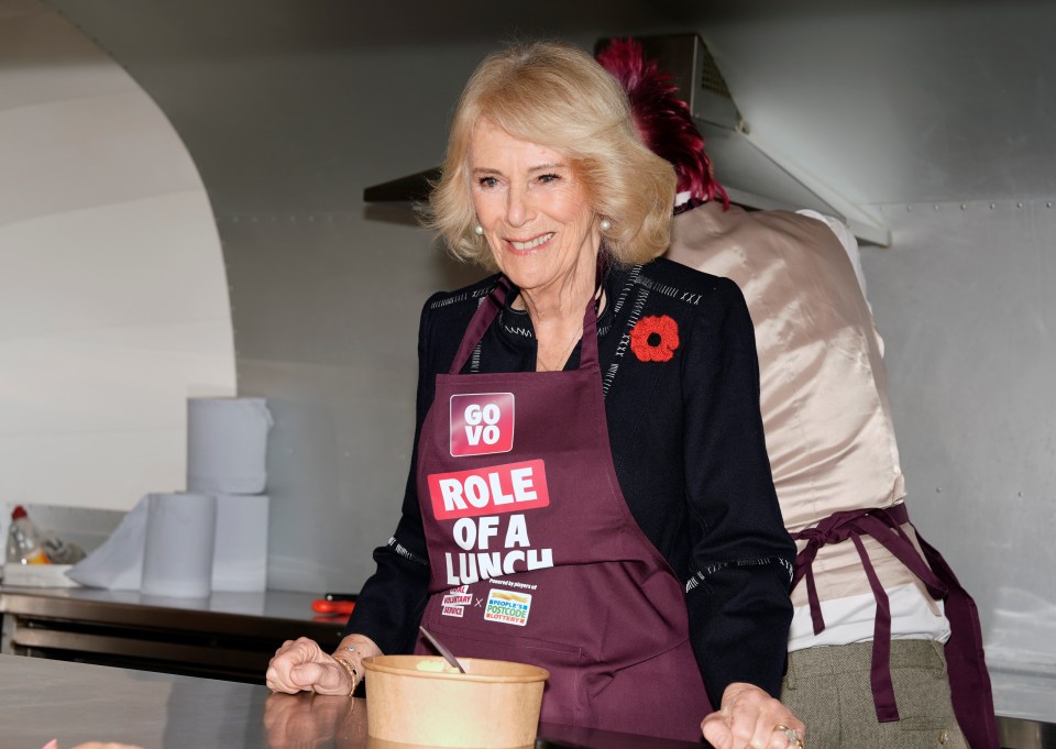 Queen Camilla in a maroon apron with "GoVo Role of a Lunch" logo, standing inside a street food truck.