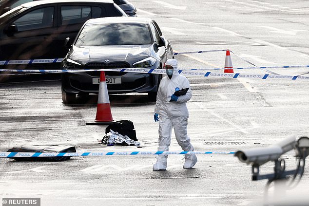 The father's BMW pictured within the police cordon on Sunday, following the attack which saw ten people stabbed on a train. It remained there on Tuesday
