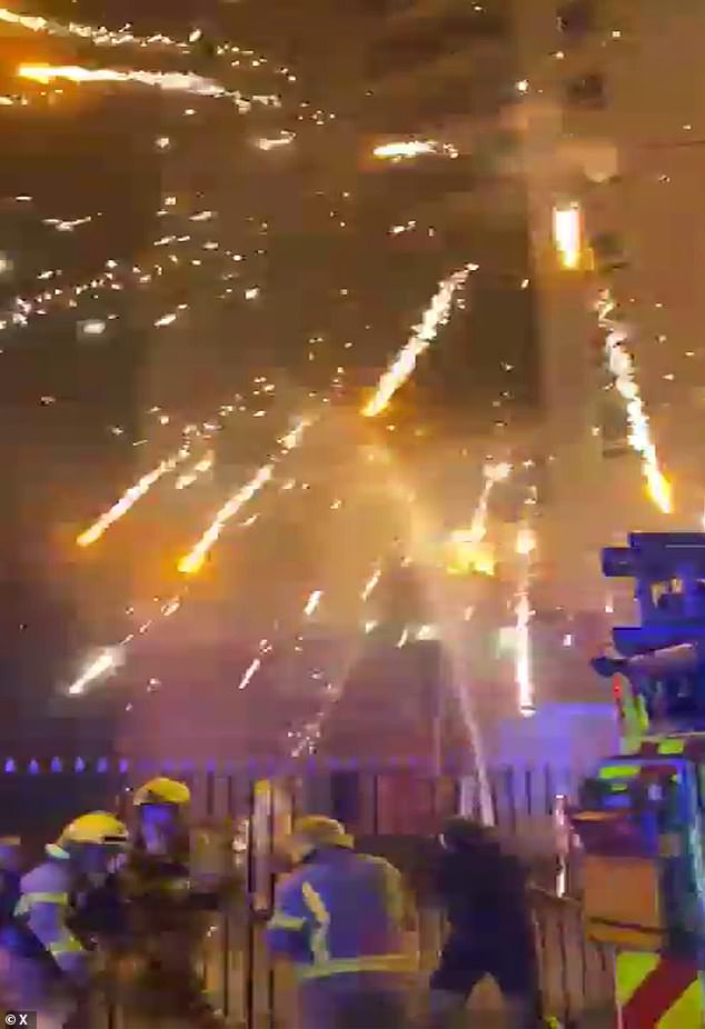 Emergency services duck for cover as fireworks explode overhead in Liverpool on Bonfire Night after being thrown by thugs