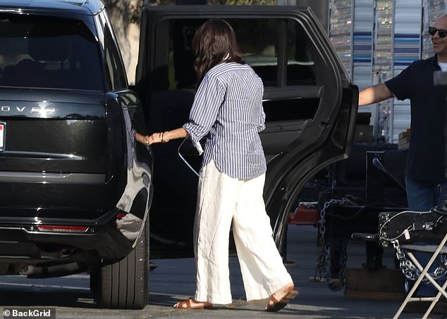 The door of the Range Rover was held for her as she jumped in. Harry is said to be thrilled for her