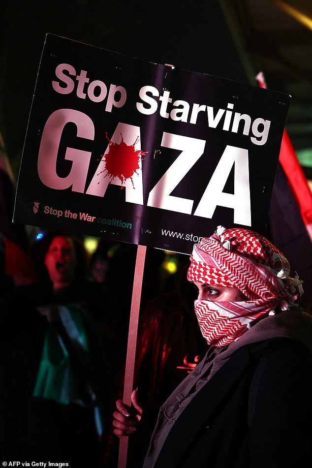 A protester pictured with a 'stop starving Gaza' placard on Thursday night