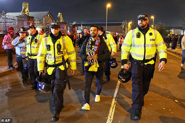 A solo Maccabi Tel Aviv fan is escorted by police along the roads by Villa Park