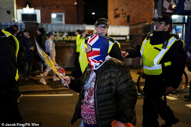 A pro-Israel fan is led by police along the streets of Birmingham before the Champions League fixture