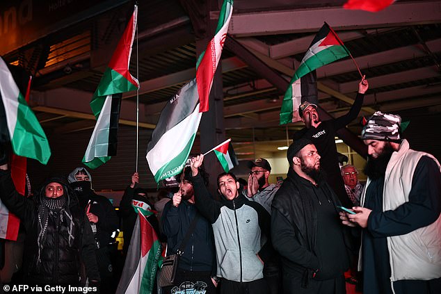 Demonstrators wave Palestinian flags in Birmingham ahead of the match. There were fears of mob violence in the lead-up to the game
