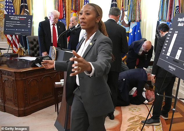 Dr Mehmet Oz and others help a drug company executive who passed out during an event in the Oval Office where Trump was announcing drug price reductions
