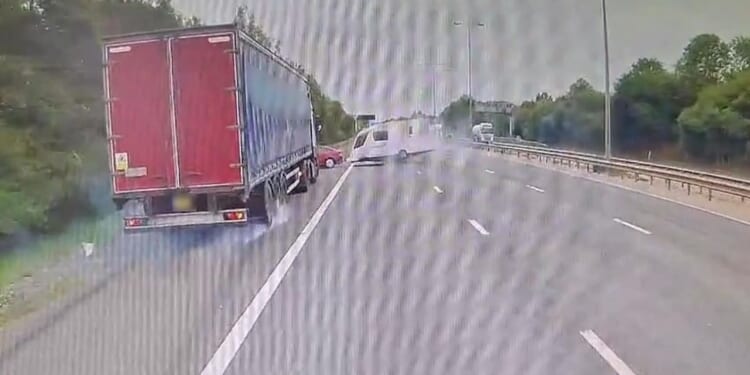 Terrifying moment car towing caravan loses control on motorway as it overtakes lorry before flipping onto hard shoulder
