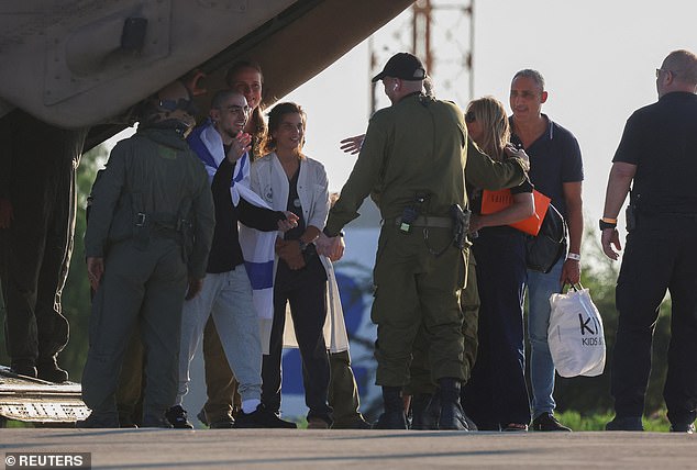 Mr Braslavski was freed last month amid a ceasefire deal between Israel and Hamas in Gaza. He is pictured here draped in the Israeli flag as he greeted members of the IDF following his release on October 13