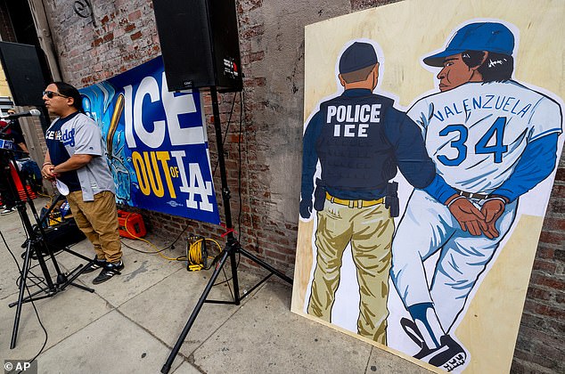 An outdoor news conference included a poster inspired by artist Sergio D. Robleto¿s painting of an ICE officer arresting late Mexican icon and Dodgers legend Fernando Valenzuela