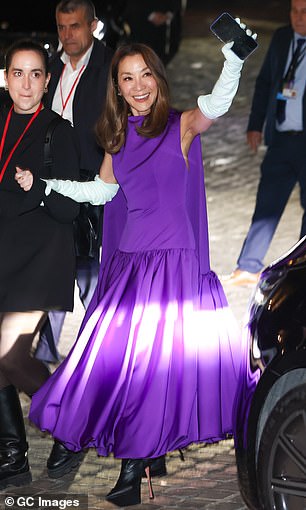 Michelle Yeoh, 63, who plays Madame Morrible, was also dressed to impress in a purple caped evening gown which she teamed with white opera gloves
