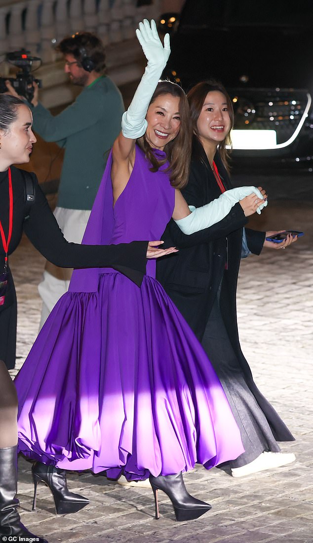 Michelle, 63, who plays Madame Morrible, was also dressed to impress in a purple caped evening gown which she teamed with white opera gloves