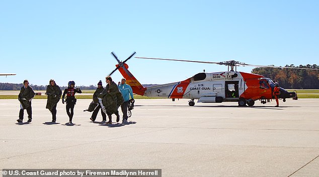 One Coast Guard photo showed the five men stepping off the helicopter onto dry land after the rescue (pictured)