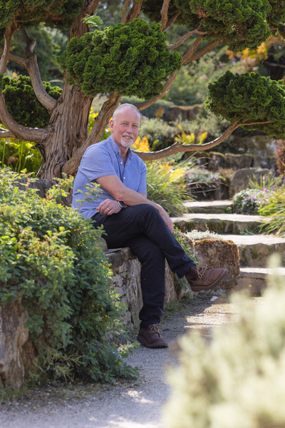 Rob Brett, Curator at RHS Wisley, sitting in a garden.