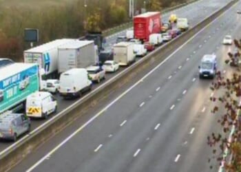 M1 closed in one direction after car hits barrier and comes to rest on its side with drivers warned of delays