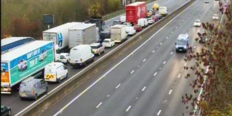 M1 closed in one direction after car hits barrier and comes to rest on its side with drivers warned of delays