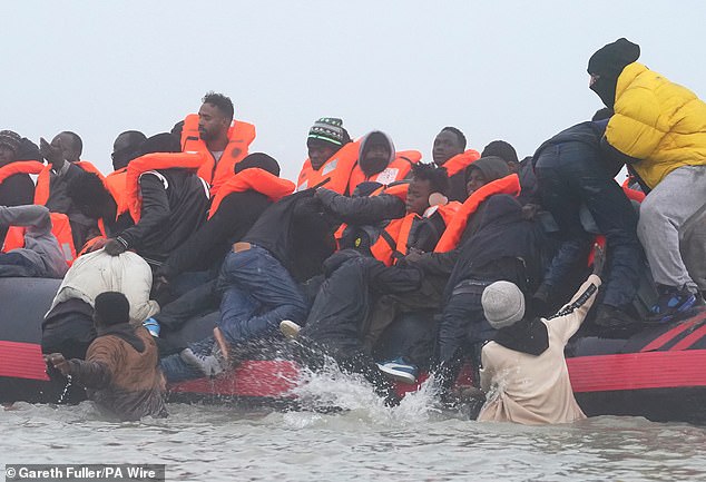 People thought to be migrants board a small boat in Gravelines, France, on Friday