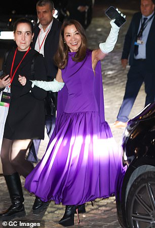 Michelle Yeoh, 63, who plays Madame Morrible, was also dressed to impress in a purple caped evening gown which she teamed with white opera gloves