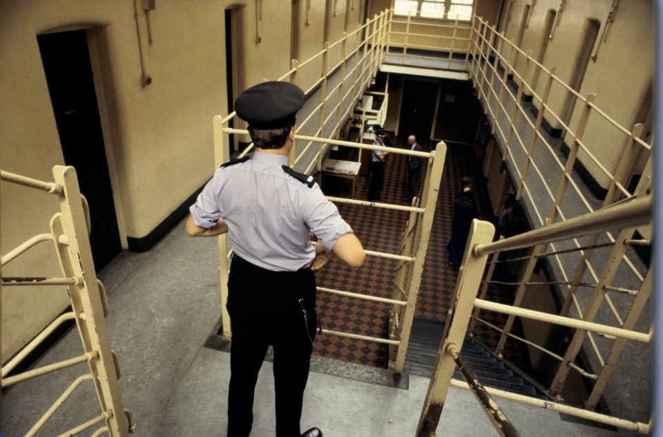 A prison warden overlooks the prison cells and inmates at Saughton prison, Scotland.