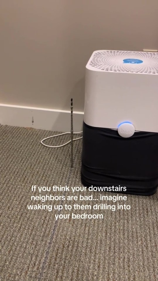A drill bit protruding from the floor next to an air purifier.