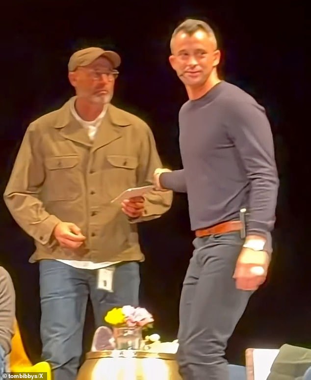 Altman remained seated, appearing somewhat confused, as theater security quickly escorted the man off the stage. Meanwhile, Yekutiel handed the piece of paper over Altman¿s shoulder to another person (pictured)